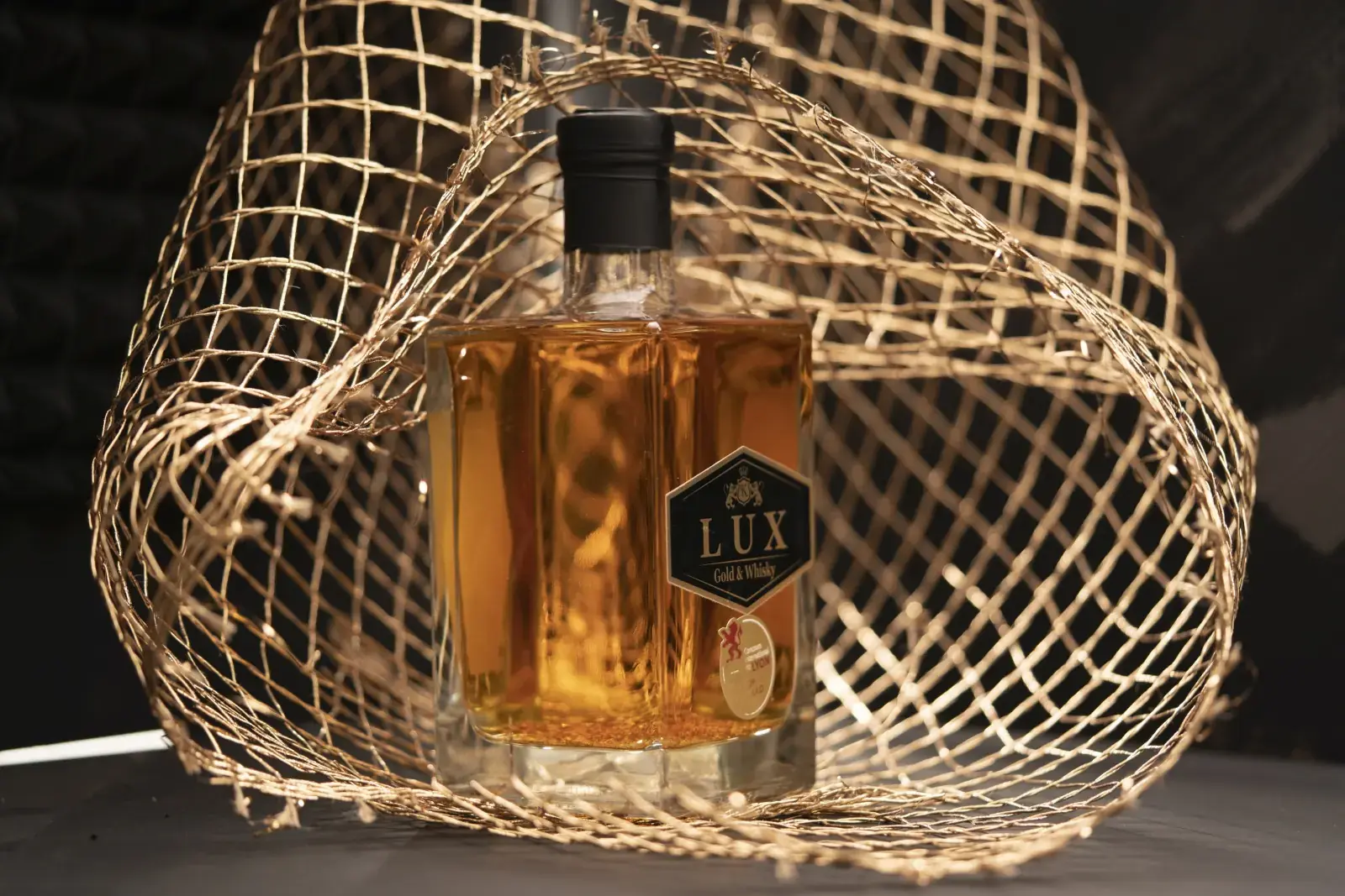 Sticlă de LUX Whisky cu fulgi de aur de 23K, pe fundal negru
