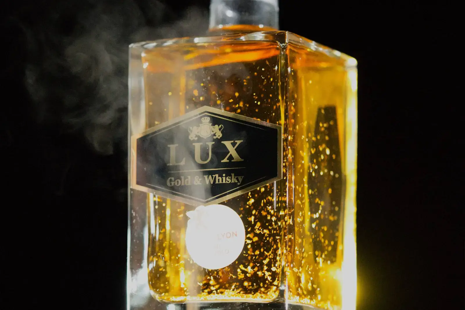Sticlă de LUX Whisky învăluită în fum, pe fundal negru