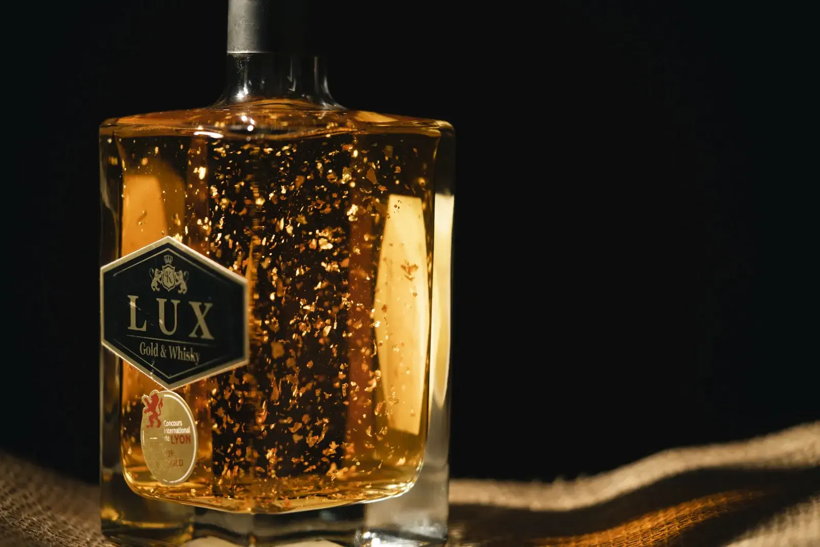 Sticlă de LUX Whisky cu aur, într-o plasă aurie